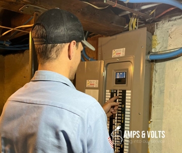 worker looking inside a breaker box in a basement