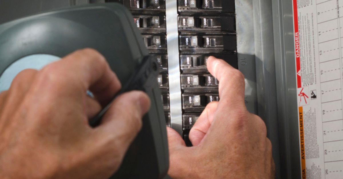 hand shining light on an electrical panel